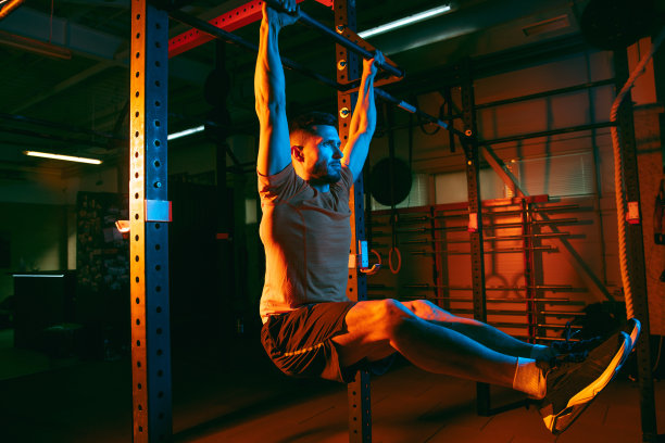 年轻的运动员，健身教练在混合霓虹灯光下训练。图片下载