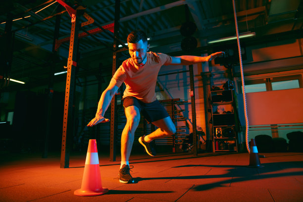 年轻的运动员，健身教练在混合霓虹灯光下训练。图片下载