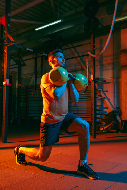 年轻的运动员，健身教练在混合霓虹灯光下训练。图片下载