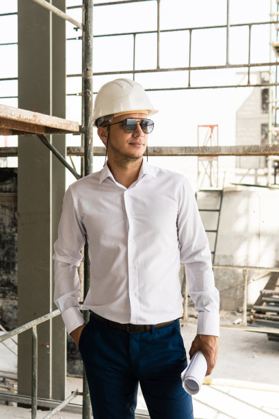 建筑工地上戴着安全帽、拿着设计图的建筑师或商人图片下载