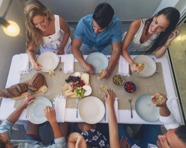 在晚宴上享用开胃菜和香槟的一群人。图片下载