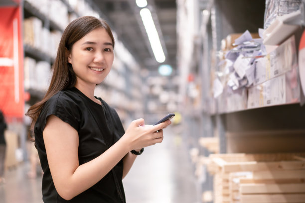 在商店里用智能手机搜索商品的女人素材图片