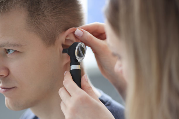 医生用手拿着耳镜在病人面前靠近耳朵图片下载