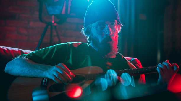 音乐家在霓虹灯下表演的特写。广告概念，爱好，音乐，节日，娱乐。图片下载