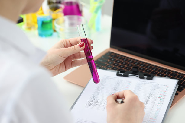 实验室员工手持装有紫色液体的试管图片下载