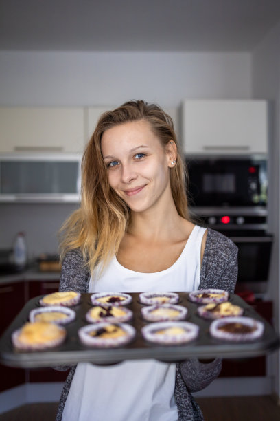 年轻漂亮的姑娘在烤无谷蛋白小杯图片下载