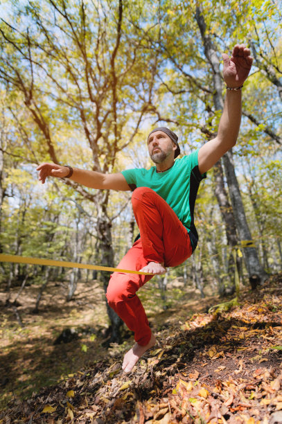 一个成熟的雄性高地人在秋天的森林里做放松线平衡训练的肖像图片下载