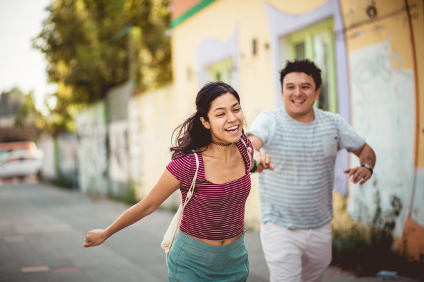 一对情侣在街上奔跑。图片下载