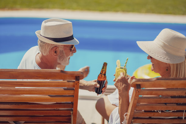 一对老年夫妇在游泳池边祝酒图片下载
