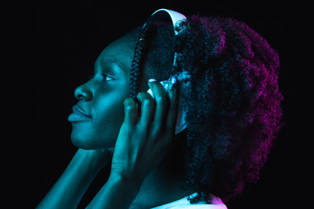 年轻美丽的非洲裔美国女孩被孤立在霓虹灯下的黑暗背景中图片下载