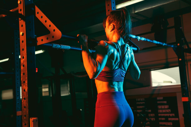 年轻的女运动员，健身教练在混合霓虹灯健身房训练。图片下载