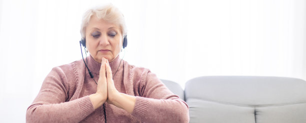 妇女双手祈祷十字架，圣经和笔记本电脑在家里图片下载
