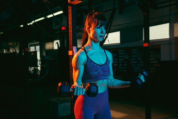 年轻的女运动员，健身教练在混合霓虹灯健身房训练。图片下载