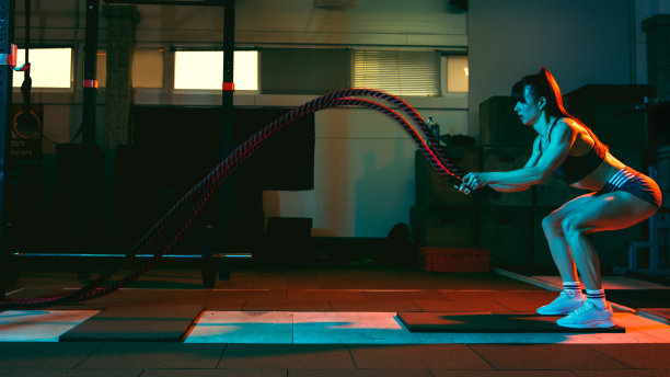 年轻的女运动员，健身教练在混合霓虹灯健身房训练。图片下载