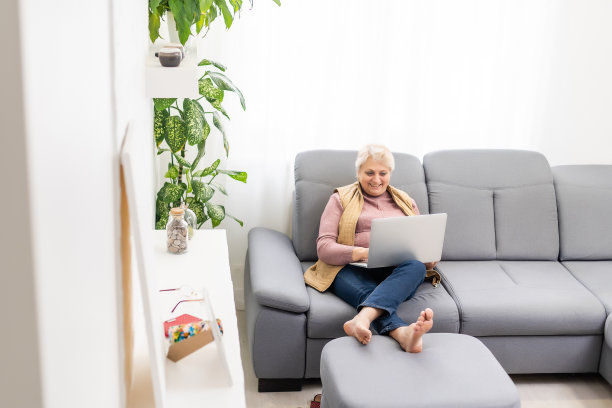 老奶奶正在和家人视频通话，微笑着挥手。检疫时间图片下载