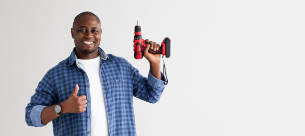 阳性非洲裔美国人，手持电钻，拇指向上，孤立在白色背景上图片下载