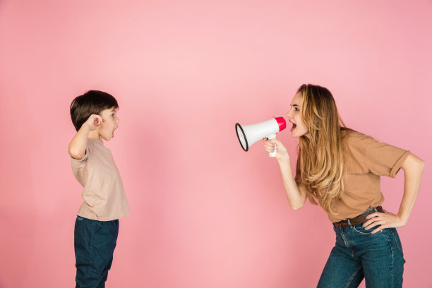 年轻的女人和小男孩，母亲和儿子孤立在粉红色的背景下。图片下载