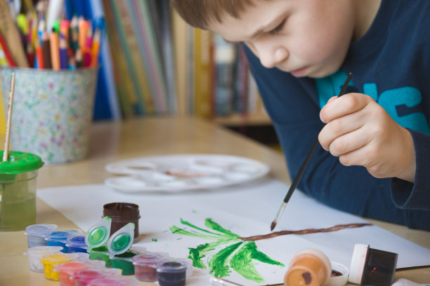 可爱的男孩坐在桌子旁画画。家庭教育。放学后和孩子一起上课。早期的发展。生活方式的概念图片下载