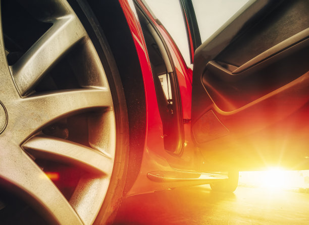 近低角度红色跑车运动边缘与门打开后，日落图片下载