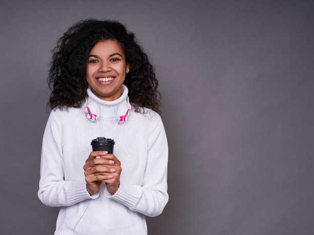 漂亮的黑皮肤女孩喝着咖啡。图片下载