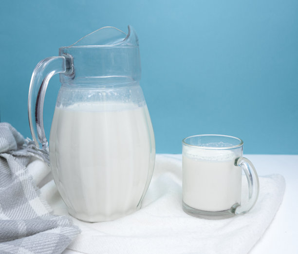 白蓝相间的背景上放着一壶新鲜牛奶图片下载