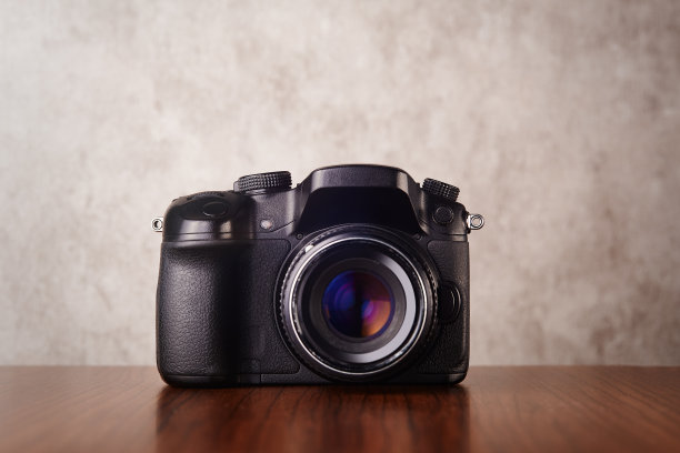 数码无反光镜专业相机木桌混凝土墙为背景图片下载