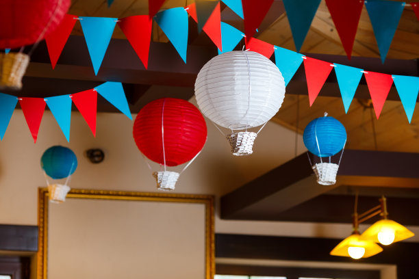 男孩一岁生日派对的照片区，有飞机和彩旗花环。装饰以蓝色、红色和白色，气球或航空主题，室内图片下载