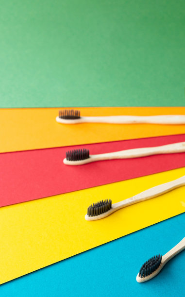 有机竹制牙刷在明亮的多色背景上组成。自然的口腔卫生。零浪费保护牙齿。图片下载