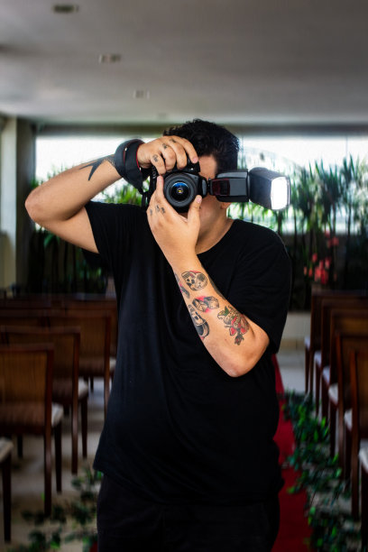 一名纹身男子用他的专业相机拍摄婚礼图片下载