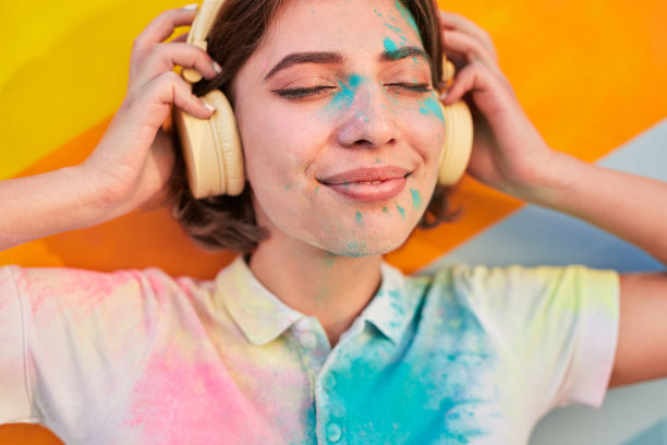 年轻女性脸上涂着颜料听音乐图片下载