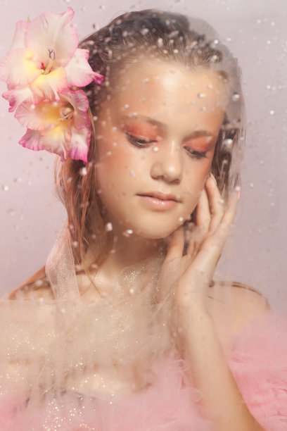 年轻漂亮的女人，有着完美的皮肤，头发上插着剑兰花图片下载