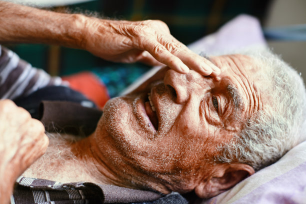 躺在床上哭泣的老人用手擦眼泪。这对老人来说是个坏消息图片下载