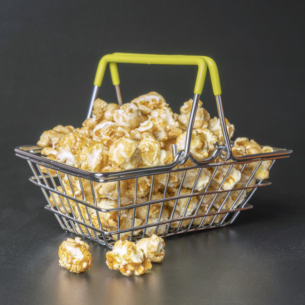 钢铁超市篮子与爆米花在一个黑色的背景特写图片下载