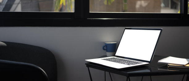 办公室玻璃桌上的笔记本电脑，空屏幕。图片下载