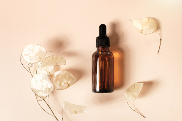 棕色血清或油玻璃模拟瓶与移液管在淡粉色背景。月神复活的背景。天然有机美容、美容、皮肤科学的概念。平躺，靠近。图片下载