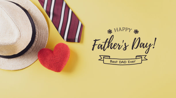 用彩色的领带，红心和帽子在柔和的黄色背景上的题词父亲节快乐。图片下载