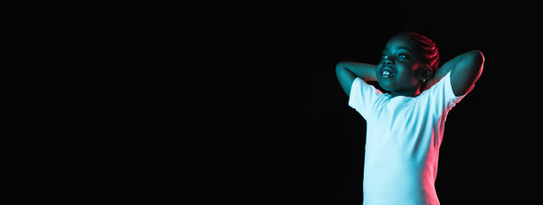 一个非洲裔美国小女孩的肖像，在霓虹灯的黑色背景下被孤立图片下载