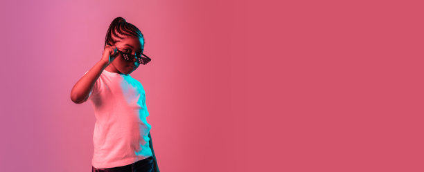 一个非洲裔美国小女孩的肖像，在霓虹灯的粉红色背景上被孤立图片下载