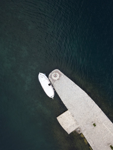 无人驾驶飞机的照片。这艘船停泊在黑山科托湾佩拉斯特附近的礁石圣母岛上的灯塔上。极简主义空中摄影。石头高原。深蓝色的亚得里亚海。图片下载