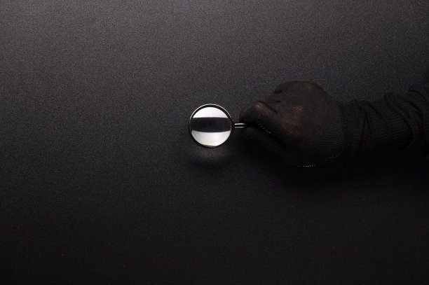 手里拿着放大镜。黑手拿着放大镜。寻找小事情和细节。图片下载