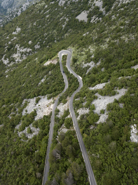 从空中俯瞰森林蜿蜒的山路，黑山。弯弯曲曲的山路上，茂密的植被，地中海灌木。地平线上的山脉。夏天。旅游对自然图片下载