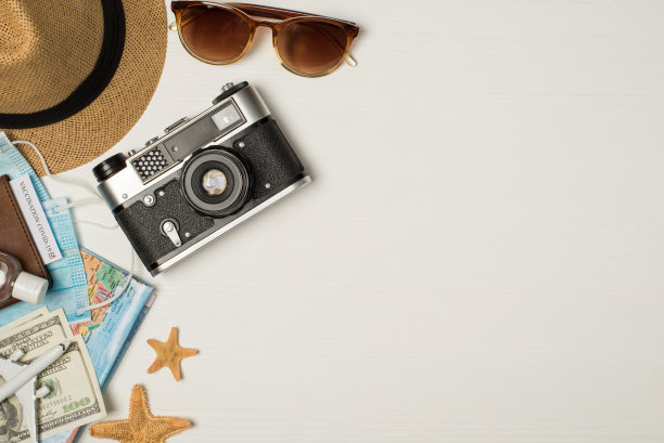 顶视图照片太阳帽太阳镜相机地图消毒剂护照封面与疫苗证书医疗口罩海星美元和飞机模型孤立的木制白色背景与拷贝空间图片下载