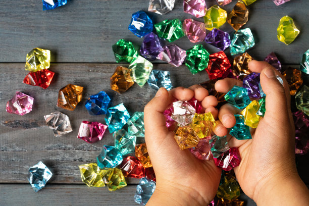 一个孩子的手抓着一块彩色的亚克力石图片下载