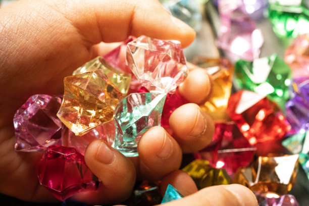 一个孩子的手抓着一块彩色的亚克力石图片下载