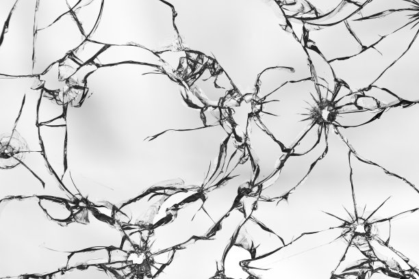 玻璃上有很多裂缝。白色背景上破碎的玻璃纹理。窗户上的弹孔图片下载