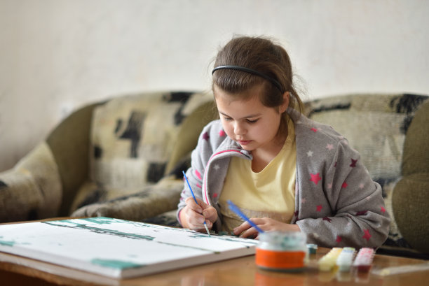 小女孩在家里用颜料画画图片下载