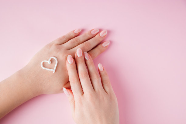 皮肤护理的概念。一位女士正在将粉底涂在手上。用于广告和设计的图像。图片下载