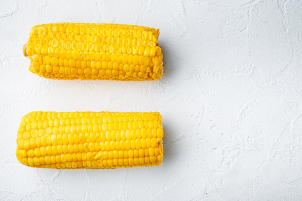 煮甜玉米芯与黄油，在白色的石头背景，顶视图平铺，与文本复制空间图片下载