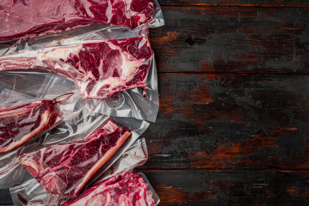 塑料市场包装的新鲜牛排，烟斗斧，t骨，棒牛排，肋眼和里脊肉，在旧的深色木桌背景，俯视图平，与文本复制空间图片下载