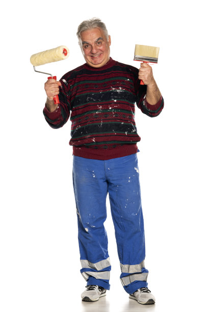 中年快乐的男人用滚筒和刷子刷墙图片下载